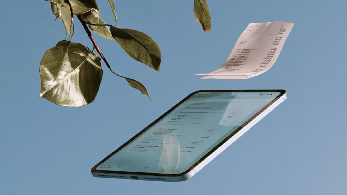 Papierrechnung schwebt auf ein Tablet mit derselben Rechnung als Datensatz